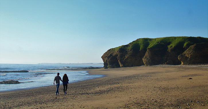 couple walking on Blackhall Rocks Beach, County Durham